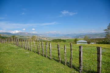 The wooden fence of a rural cottage in the heights and the beautiful view of the mountains