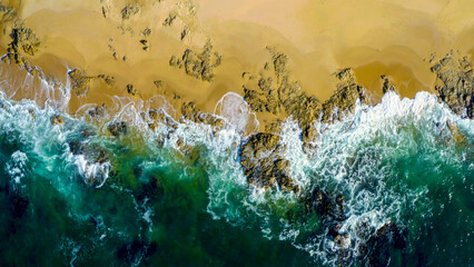 Aerial view of the ocean rocky shore. aerial view of green ocean waves splash on cliff. 