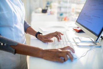 Pharmacist typing on a computer in the drugstore