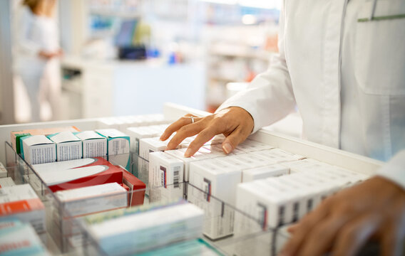 Close up of a pharmacist stacking medication in a row at the pharmacy