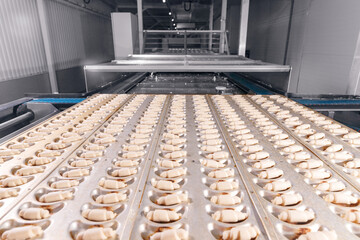 Concept smart modern technology in food industry. Process Production of French croissants, puff pastry dough pieces are automatically moved along line conveyor