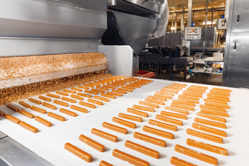 Food industry, wafer production line of modern sweet candy bakery factory. Nuts pour onto waffles...