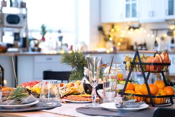 Serving a festive table with snacks, salads and goodies close-up in the modern interior of a loft house decorated for Christmas and New Year. Waiting for guests for a festive dinner