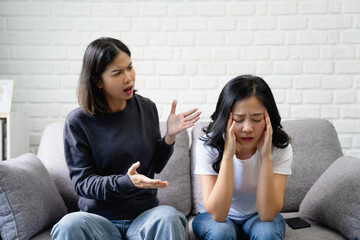 Asian lesbian couple arguing on the sofa - obrazy, fototapety, plakaty