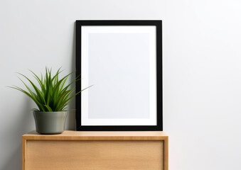 Wall art empty picture frame mockup on wooden desk, wall, table. Vase with olive branches, cactus. Elegant working space, home office concept.