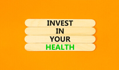 Invest in your health symbol. Concept word Invest in your health on beautiful wooden stick. Beautiful orange table orange background. Invest in your health concept. Copy space.