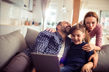 Young family with laptop on the couch