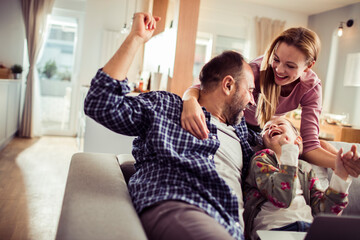 Young family having fun on the sofa at home