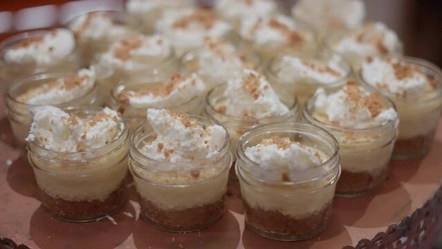 Serving table with jars filled with chocolate cheesecake shooters
