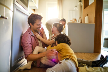 Happy dad playing with his kids on the floor
