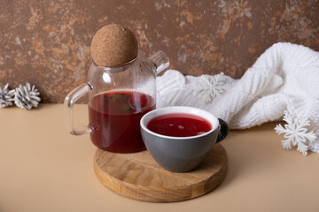 Cup and teapot with cranberry tea with winter decorating. Warm drink still life