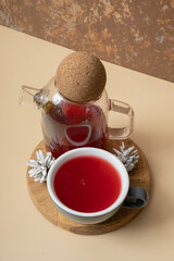 Cup and teapot with cranberry tea with snowy cones. Warm drink still life