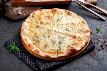 Pizza four cheeses on a dark background. Pizza 4 cheeses with gorgonzola, cheddar, mozzarella and parmesan.