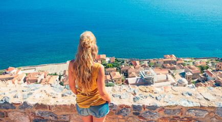 Woman looking at panoramic view of Monemvasia town panoramic view- Travel, tour tourism in Greece, Peloponnese