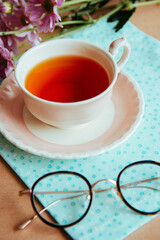 Taza de té y anteojos en la mesa