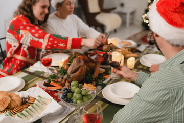 Holidays, celebration and people concept - happy friends with sparklers having christmas dinner at home