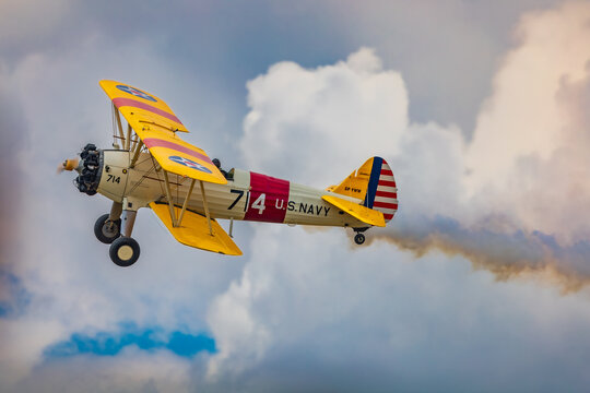 Leszno, Poland - June 17 2023: Antidotum Airshow Leszno 2023 and acrobatic shows of yellow Boeing Stearman plane on a blue clouy sky