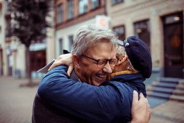 Joyful reunion of a mature couple in the city