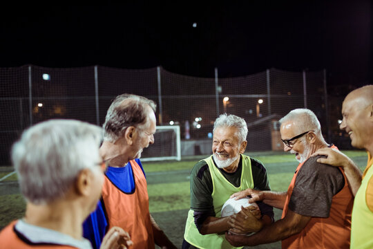 Elderly friends share a joyful moment after a football match