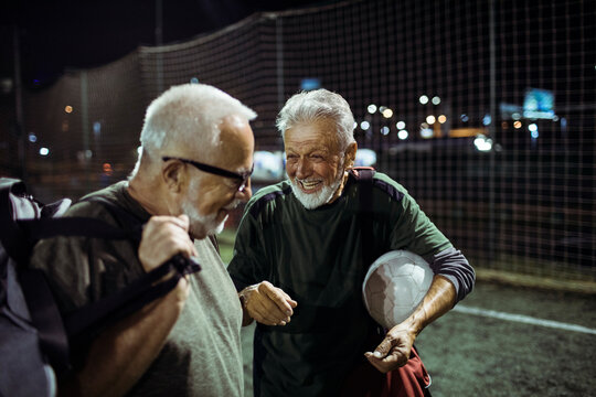 Elderly friends share a joyful moment after a football match