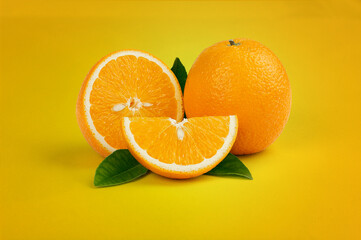 Oranges with green leaves in yellow background