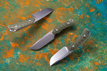 Hunting knife with a fixed blade. Knife from three angles. Knife with green handle. Levitation.