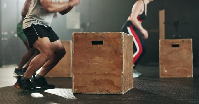 Gym, group and box jump for exercise, workout and cardio performance for muscle, power and action. Closeup legs of strong people training on wooden boxes, fitness class or energy for sports challenge