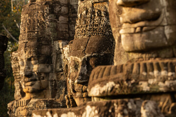 Enigmatic stone faces sculpted in the Bayon temple, illuminated by the last rays of the evening...