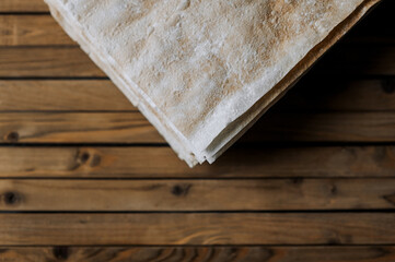 Many layers of dry dough prepared for a cake on a wooden background. Photography, cooking.