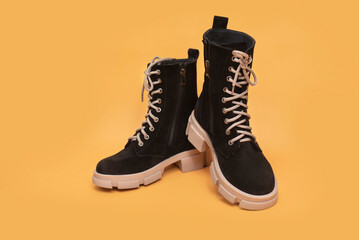 High boots with light high aggressive soles for women on orange background, suede boots for cool dry weather, autumn or spring