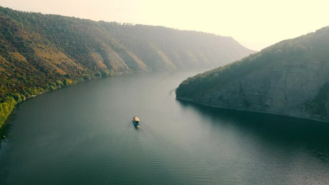 Excursion steamboat sails in the picturesque canyon of the big river. Walks and trips on excursion ships. Aerial view