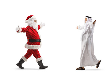 Santa claus walking towards a mature muslim man in ethnic clothes