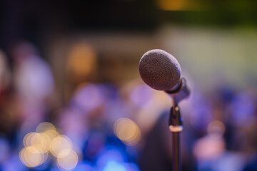 Close-up  of an isolated microphone stand against the background of a small concert venue, show...