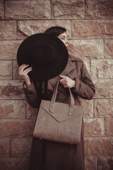 woman with a hat and leather handbag