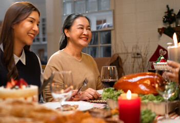 Asian family gathering at home having dinner celebrating Christmas and Grandmother is happy to...