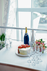 bottles as bride and groom, cake with heart-shaped cookies and strawberries, bridal bouquet