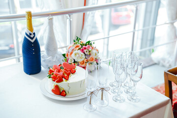 bottles as bride and groom, cake with heart-shaped cookies and strawberries, bridal bouquet