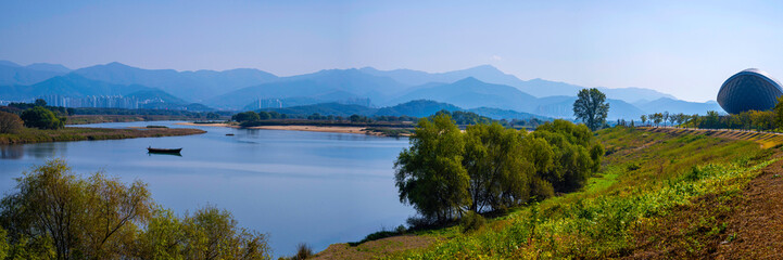 Fototapeta na wymiar Daegu City nature landscape in autumn, tranquil riverbank, forest, and mountain views over the wildlife conservation area in Nakdong River, South Korea