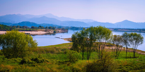 Daegu City nature landscape in autumn, tranquil riverbank, forest, and mountain views over the wildlife conservation area in Nakdong River, South Korea - Powered by Adobe