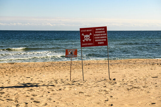 Sign with inscription in Ukrainian - Dangerous mines and no swimming allowed on the beach near the Black Sea in Odesa region, Ukraine, October 10, 2323