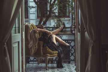 Lady in peignoir with a glass of wine. Sensual photo of European Blonde woman in black silk robe...