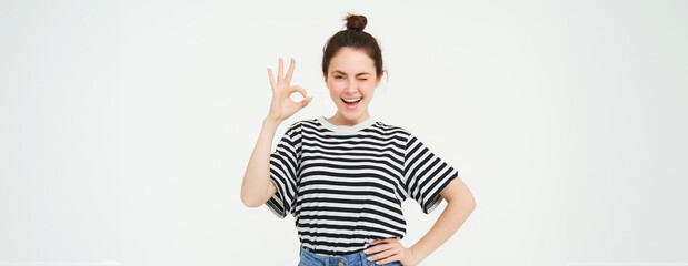 Excellent choice. Smiling stylish young woman, showing okay, ok gesture, zero sign, standing over...