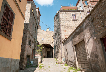 Fototapeta na wymiar narrow street with traditional old houses in the medieval old town of Viterbo, Lazio, Italy