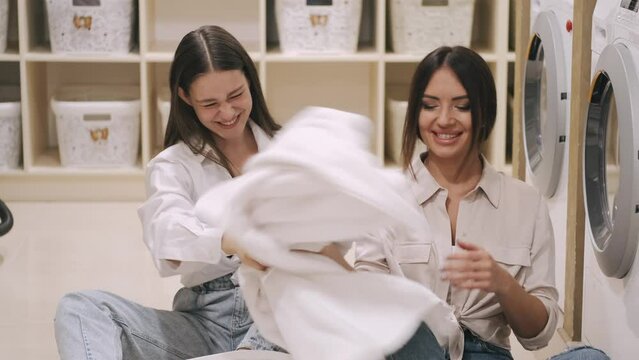 two sisters  cleaning cloath using the washer and arranging them and putting it back in the closest
