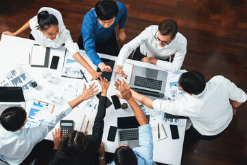 Top view diverse office worker join hand together in office room symbolize business synergy and strong productive teamwork in workplace. Cooperation and unity between business employee. Prudent - obrazy, fototapety, plakaty