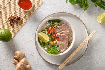 Pho Bo Soup with beef in bowl on white background. Vietnamese cuisine.
