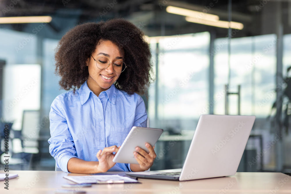 Wall mural young successful woman working with tablet computer inside office at workplace, smiling female progr