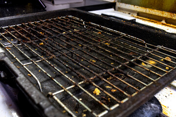 A very dirty and greays grill tray