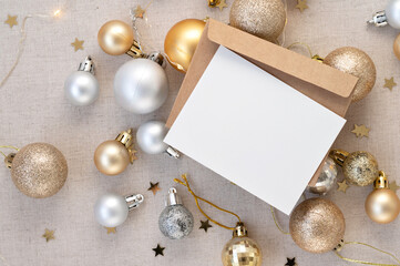 Blank paper card mockup and envelope, gold and silver ornaments, Christmas tree decoration balls,...