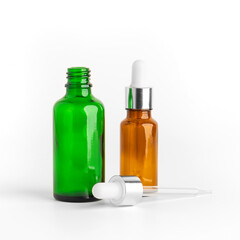Colored glass cosmetic bottle of essential oil with dropper or pipette isolated on white background. Round bottle with DropperStop.